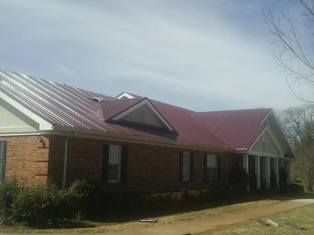 Red metal roof with gabled entries on a long brick building in Westlake